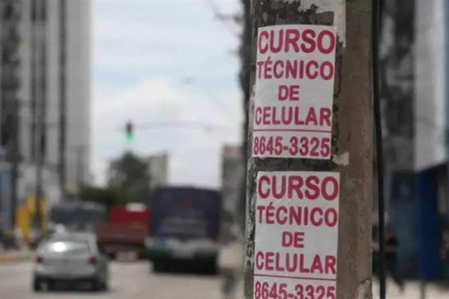 Panfletos brancos colados em um poste.